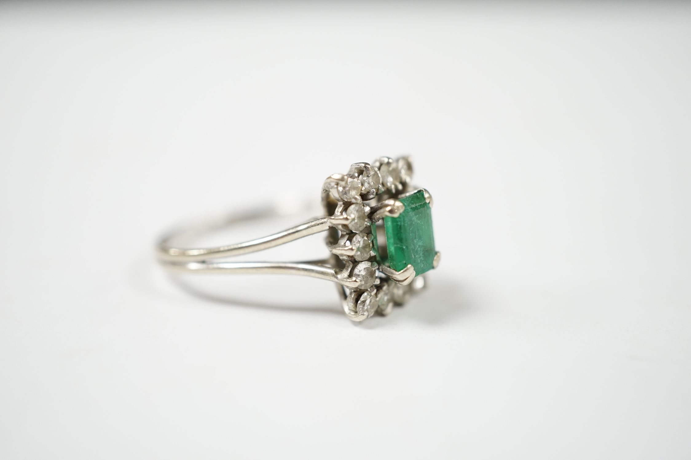 A 1960's white gold?, emerald and diamond set rectangular cluster ring, size T/S, gross weight 4.3 grams. Condition - poor